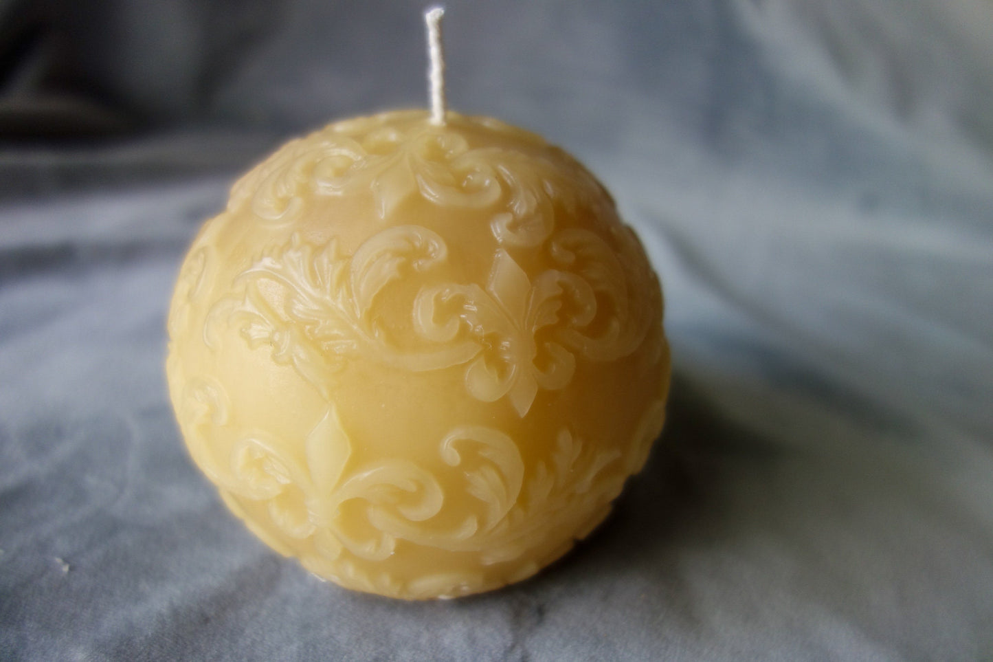 Beeswax ball candle with fleur-de-lis pattern