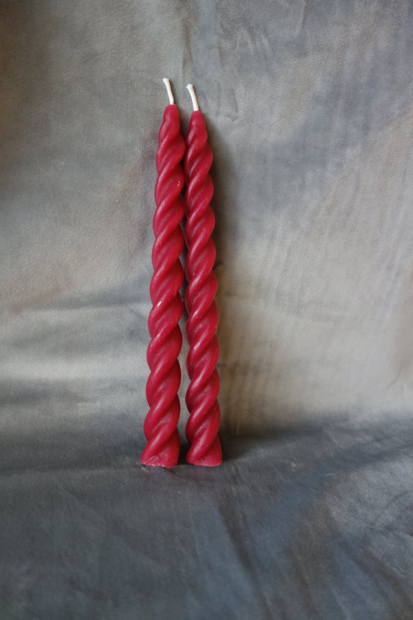 Two red spiral twisted beeswax tapers 7 inches